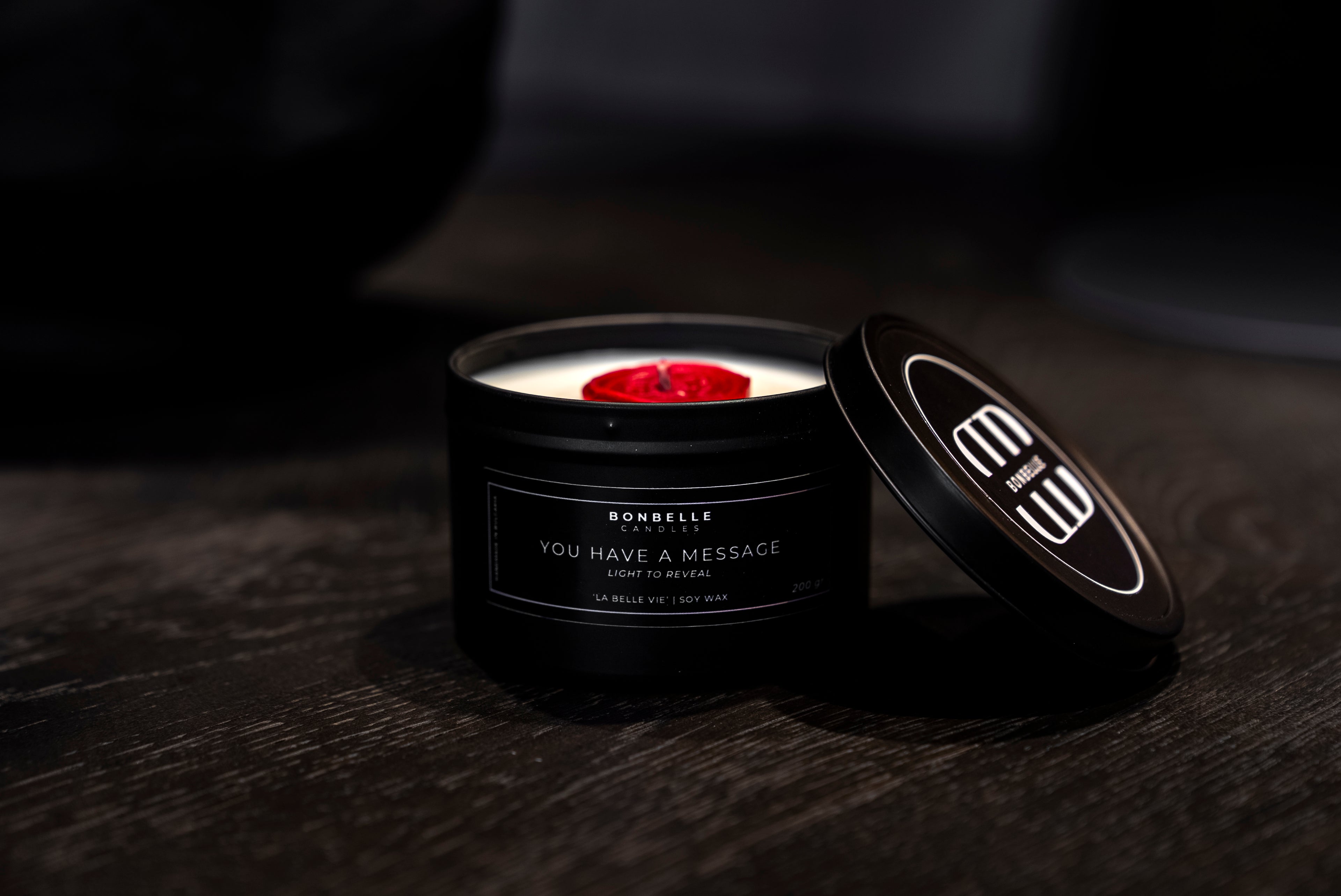 Black candle with a red wick on a dark surface